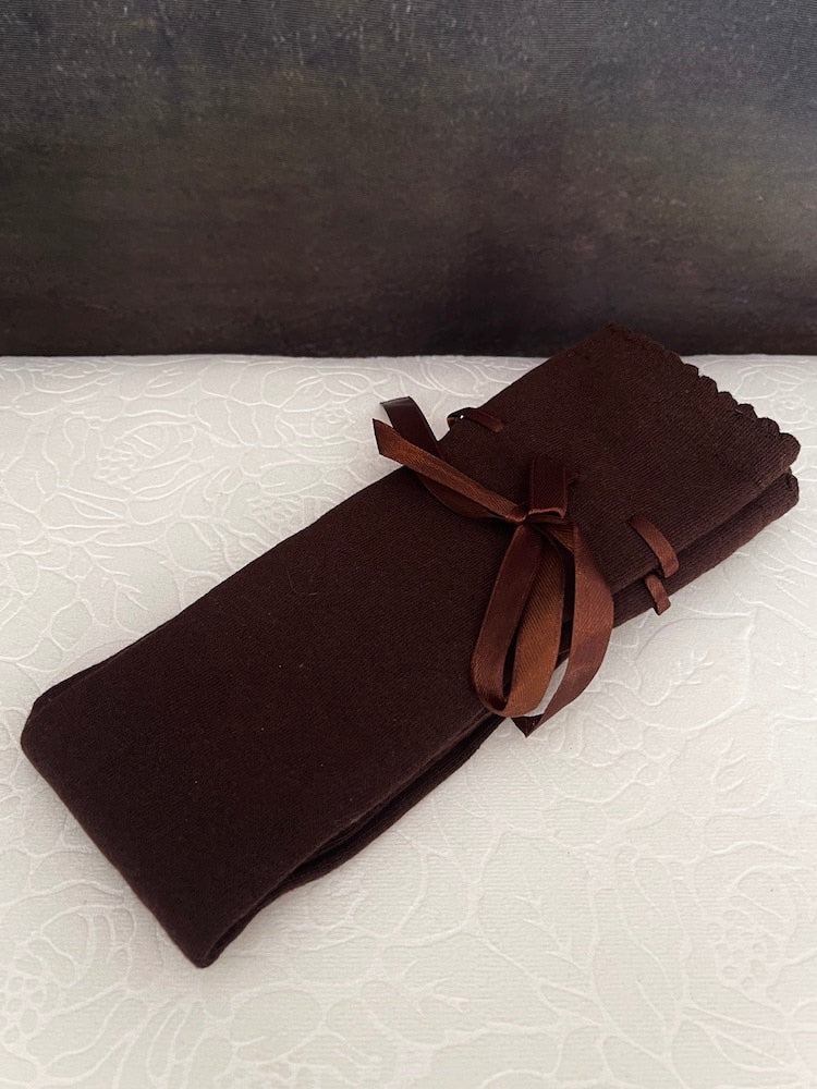 A pair of brown historically inspired knee high stocking socks with ribbon laced bow