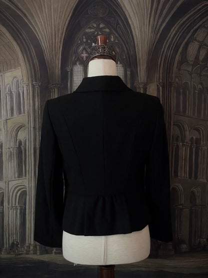 Historically inspired Victorian-inspired tailored ruffle jabot jacket coat with button front.