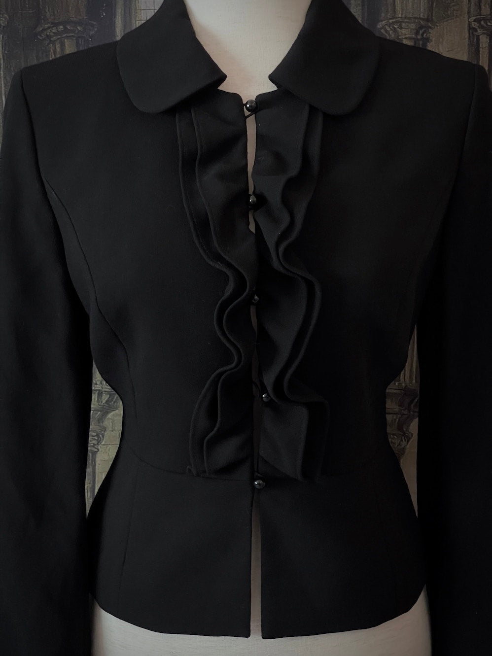 Historically inspired Victorian-inspired tailored ruffle jabot jacket coat with button front.