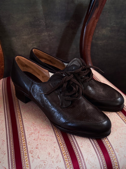 Dark brown leather vintage 1970s oxford derby shoes with heels and a textured pattern. Reminiscent of the 1940's. Pictured on a red and cream striped chair.