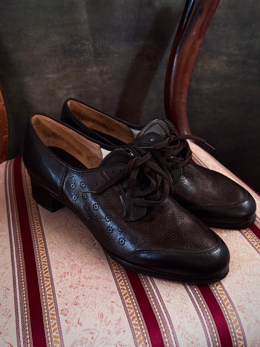 Dark brown leather vintage 1970s oxford derby shoes with heels and a textured pattern. Reminiscent of the 1940's. Pictured on a red and cream striped chair.